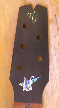 A close up photo of the inlay on the headstock of Mandonator 11